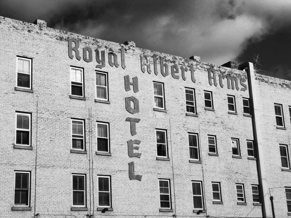 The Royal Albert Arms Hotel sign painted on the building's brick facade